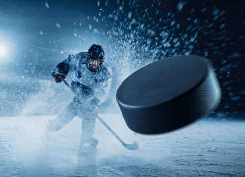 Professional Ice Hockey Player Shooting the Puck with Hockey Stick.