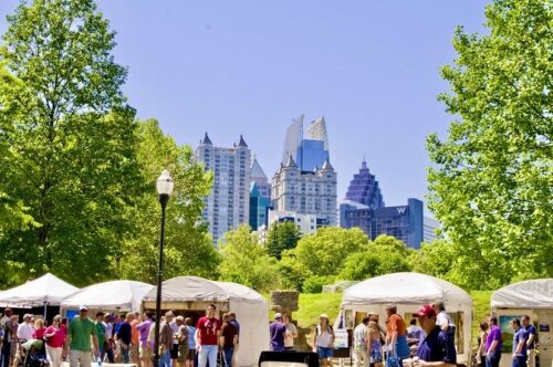 Groups of people, outside, looking at vendor tents at The Piedmont Park Arts Festival