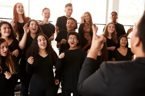 a group of highshcool students dressed in all black while attending choir rehearsals