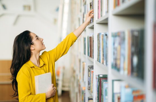 woman choosing a book from a row at hall county library