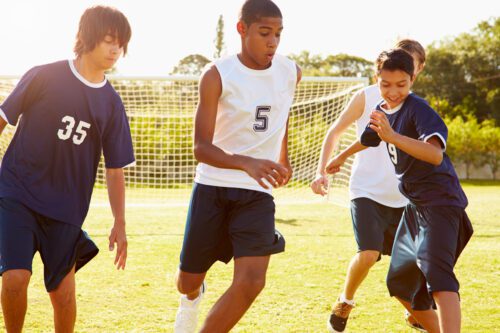 Diverse group of high school boys playing a game of soccer