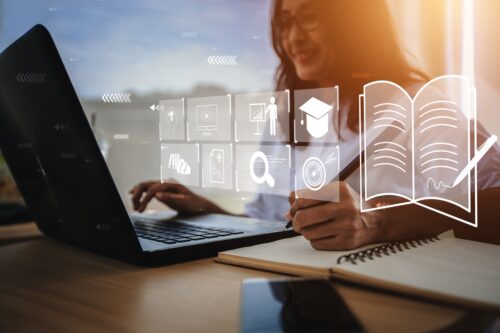 image of a woman working at her computer, with icons in front of the computer screen representing all interfaces and softwares that can be accessed on the computer