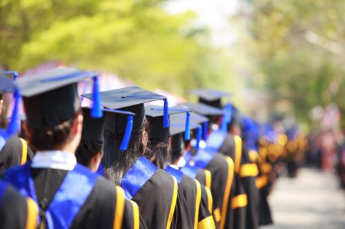 A line of students in their cap and gowns, waiting to receive their diplomas at high schools in Gwinnett county