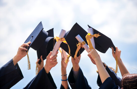 group of students holding their caps and diplomas after graduation from high schools in cherokee county