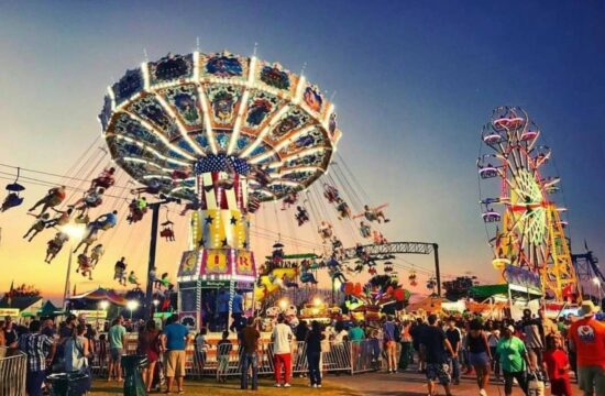 large sky chair ride at the fair, with some people in the foreground.